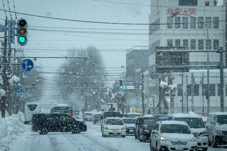 a city street filled with lots of traffic covered in snow