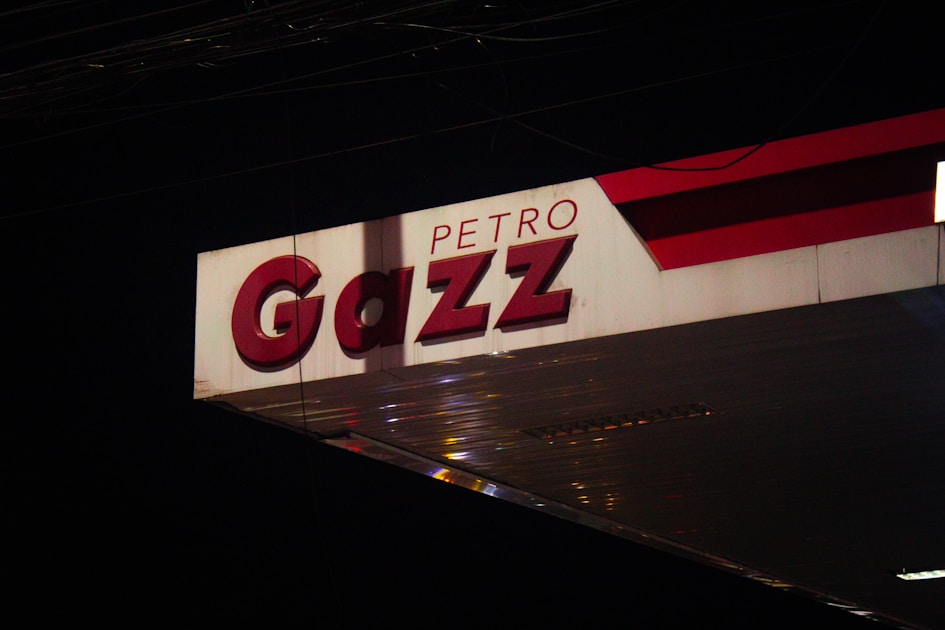 A gas station sign at night displays 