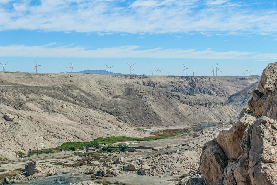 a view of a valley with wind mills in the distance