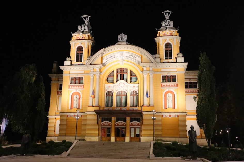 A large yellow building with two towers at night