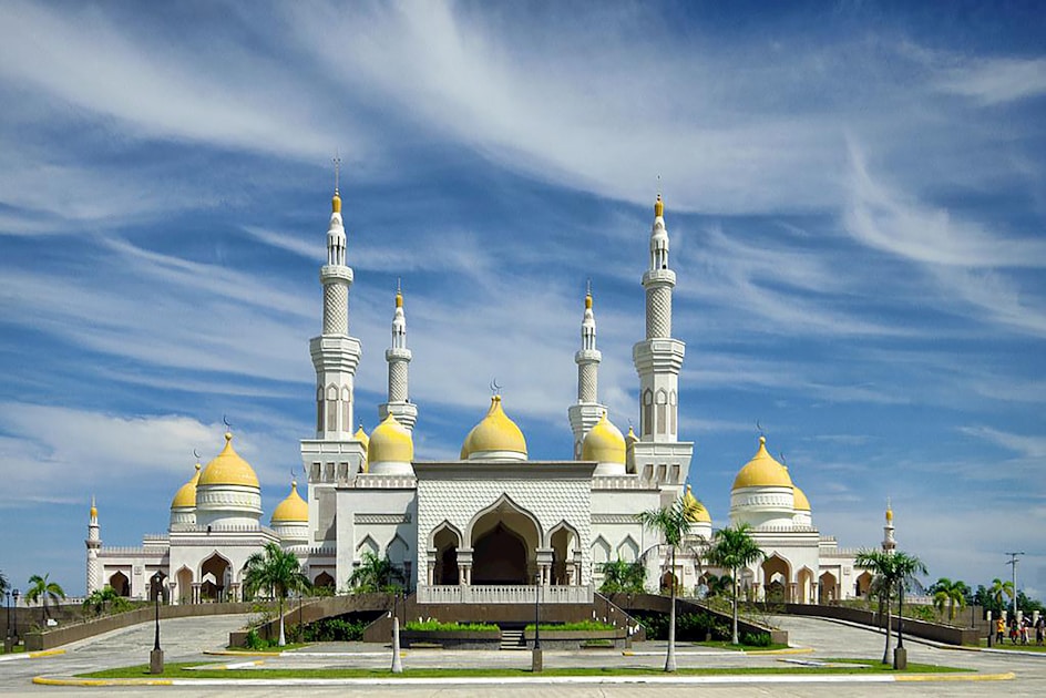 A majestic mosque stands under a blue sky.