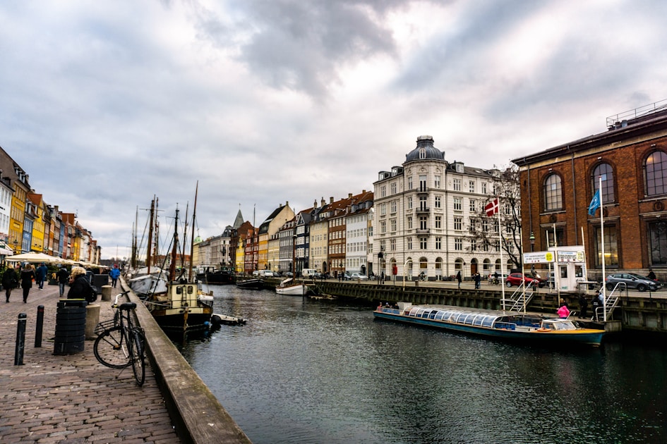 boats on body of water viewing multicolored buildings under white and gray sky during daytime