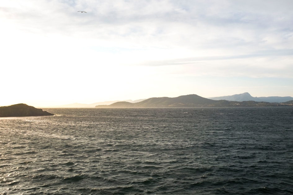 body of water during white cloudy sky