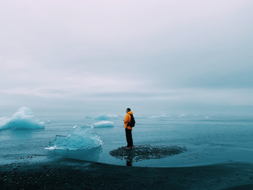 man in black shorts standing on sea shore during daytime