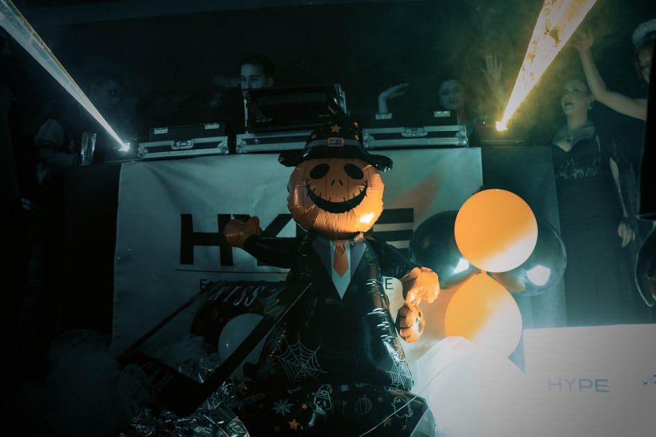 A person in a jack-o'-lantern costume parties.