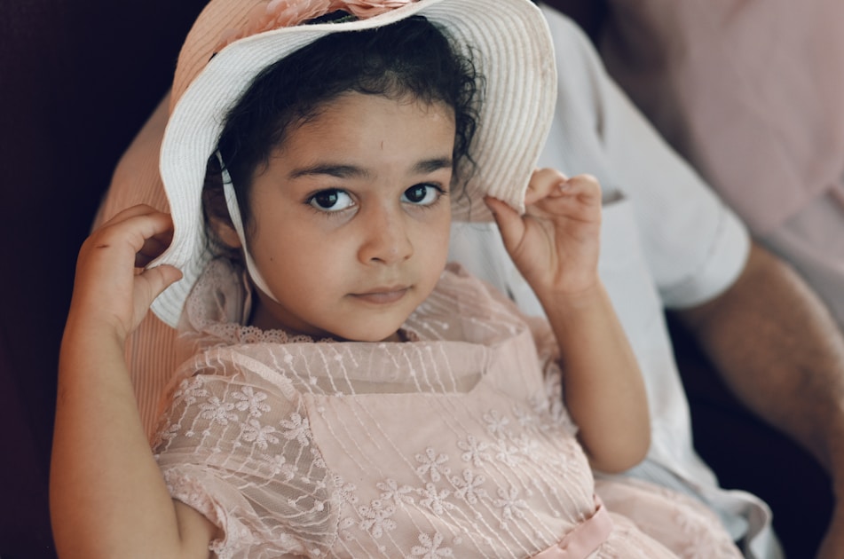 girl in white floral dress wearing white and black hat