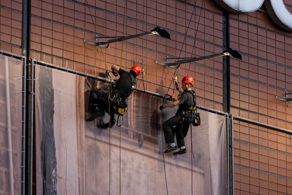 A couple of men standing on top of a tall building
