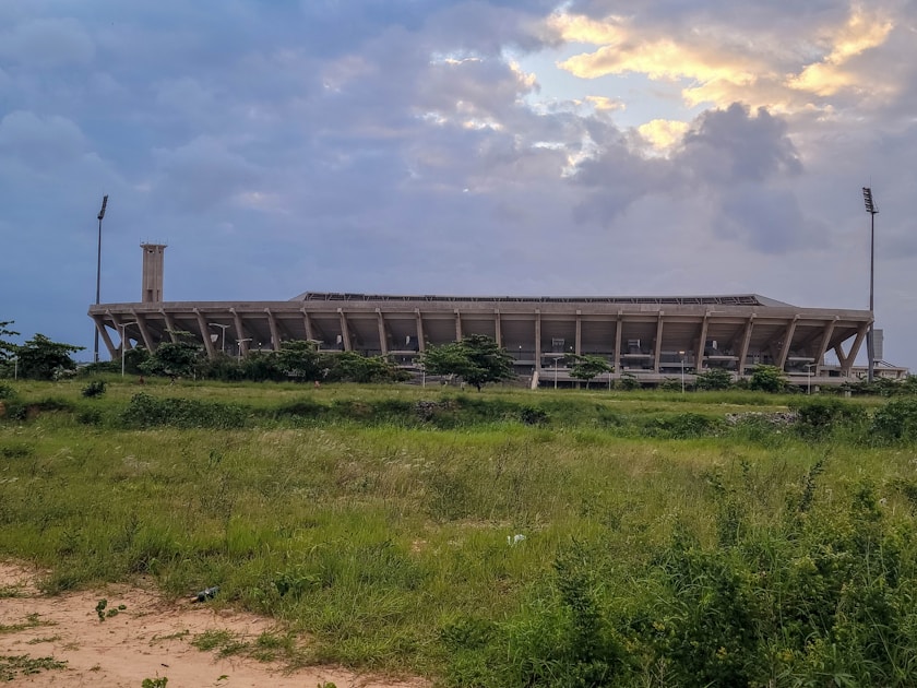 a large building sitting on top of a lush green field