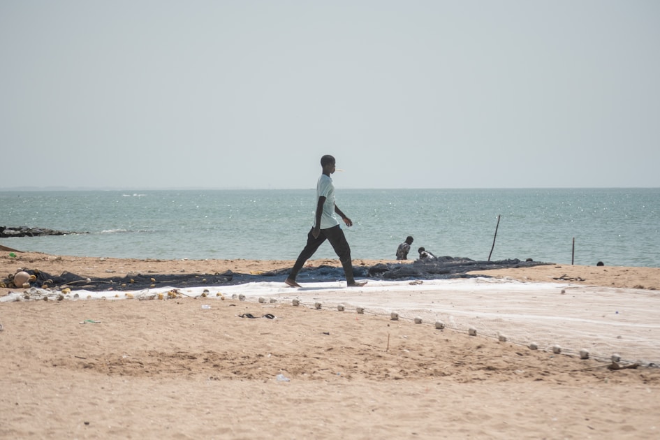 a person walking on a beach near the ocean