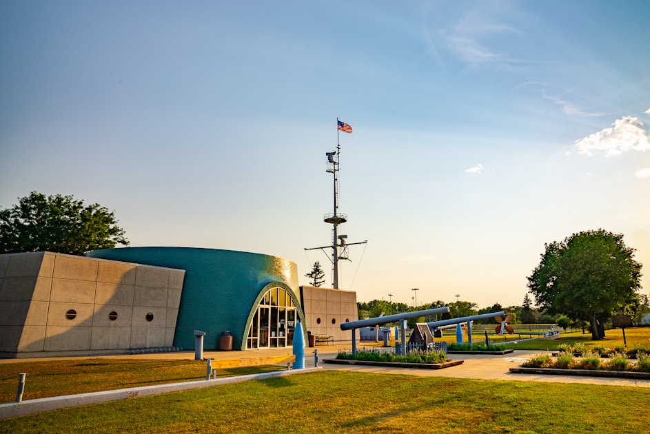 A building with a green roof and a flag pole