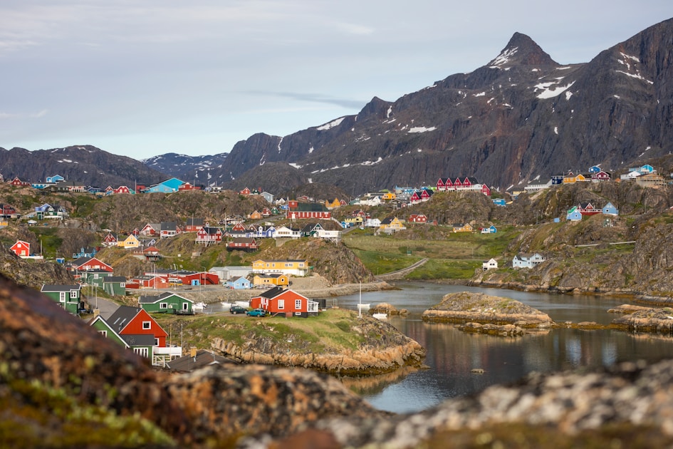 houses near lake and mountain during daytime