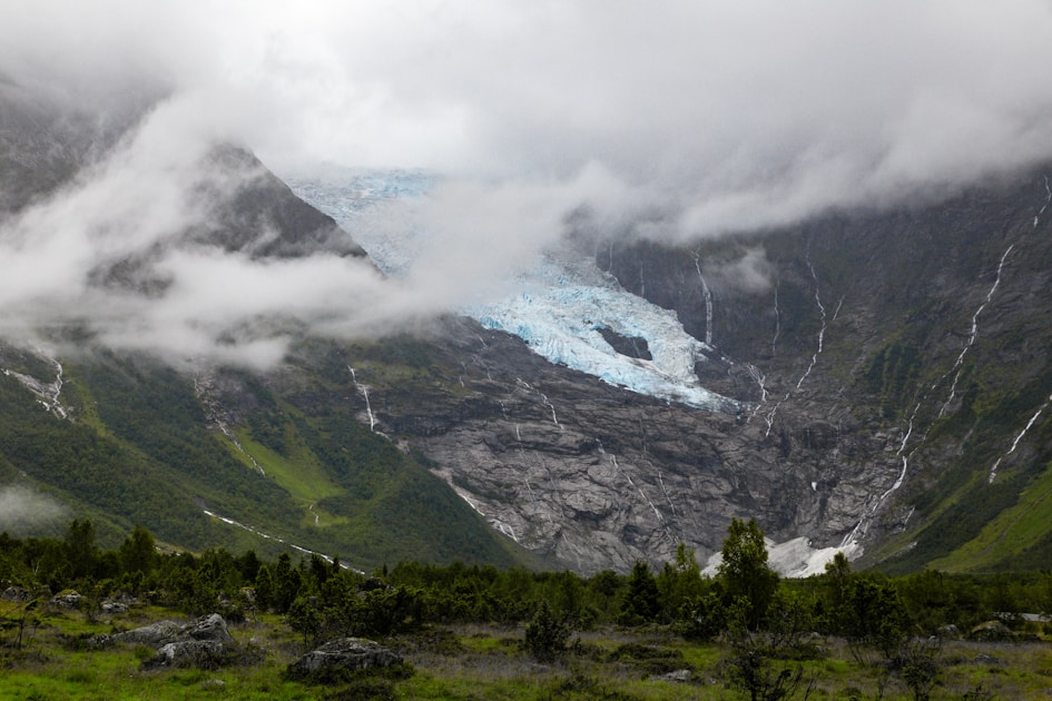 grass field mountains during cloud formation