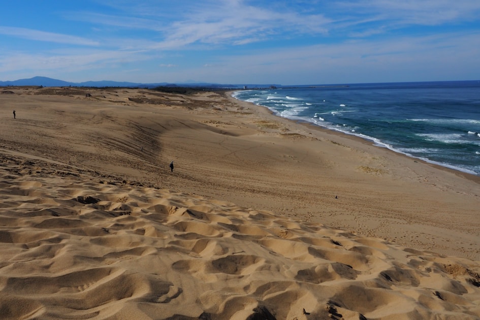 a sandy beach with waves coming in from the ocean